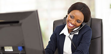 A smiling woman answering a phone