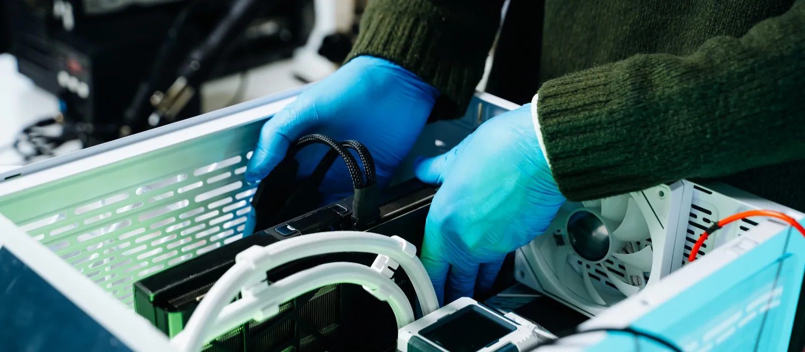 Technician in gloves installing parts in a custom PC